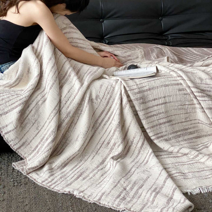 Cozy living blanket made of cotton blend fabric with fringes and striped texture