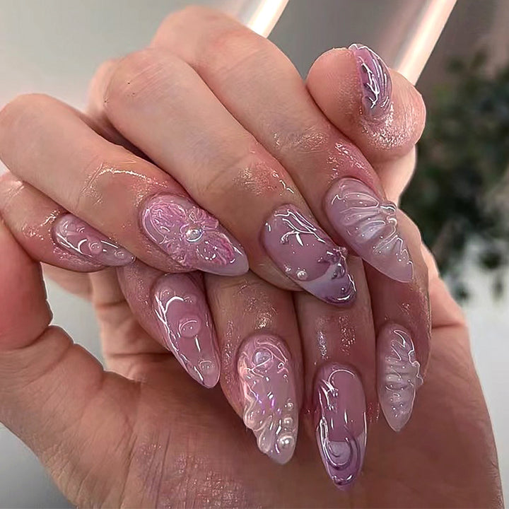 Artificial nail extensions with delicate floral designs and glitter accents Stornfield
