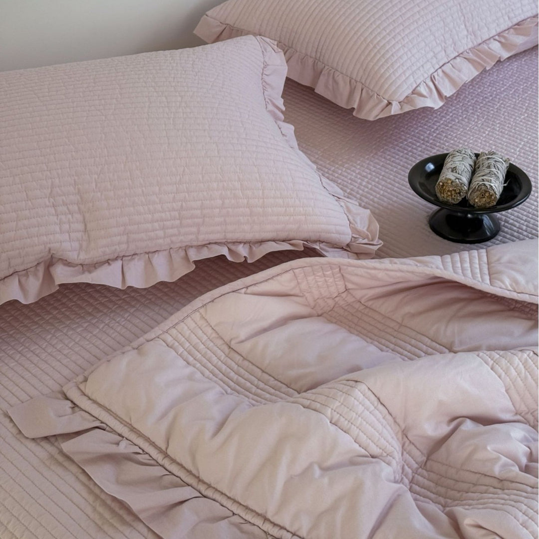 Padded quilted bedding set with ruffled trim and fine channel stitching