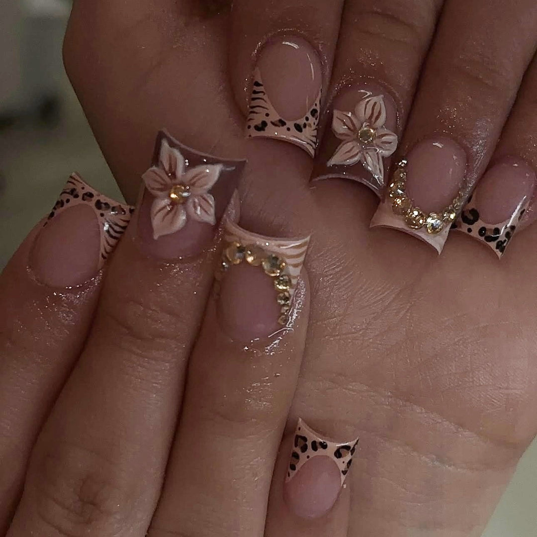 Artificial nail set with floral embellishments and elegant glitter details Stornfield
