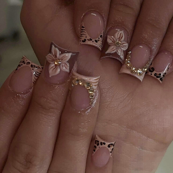 Artificial nail set with floral embellishments and elegant glitter details Stornfield
