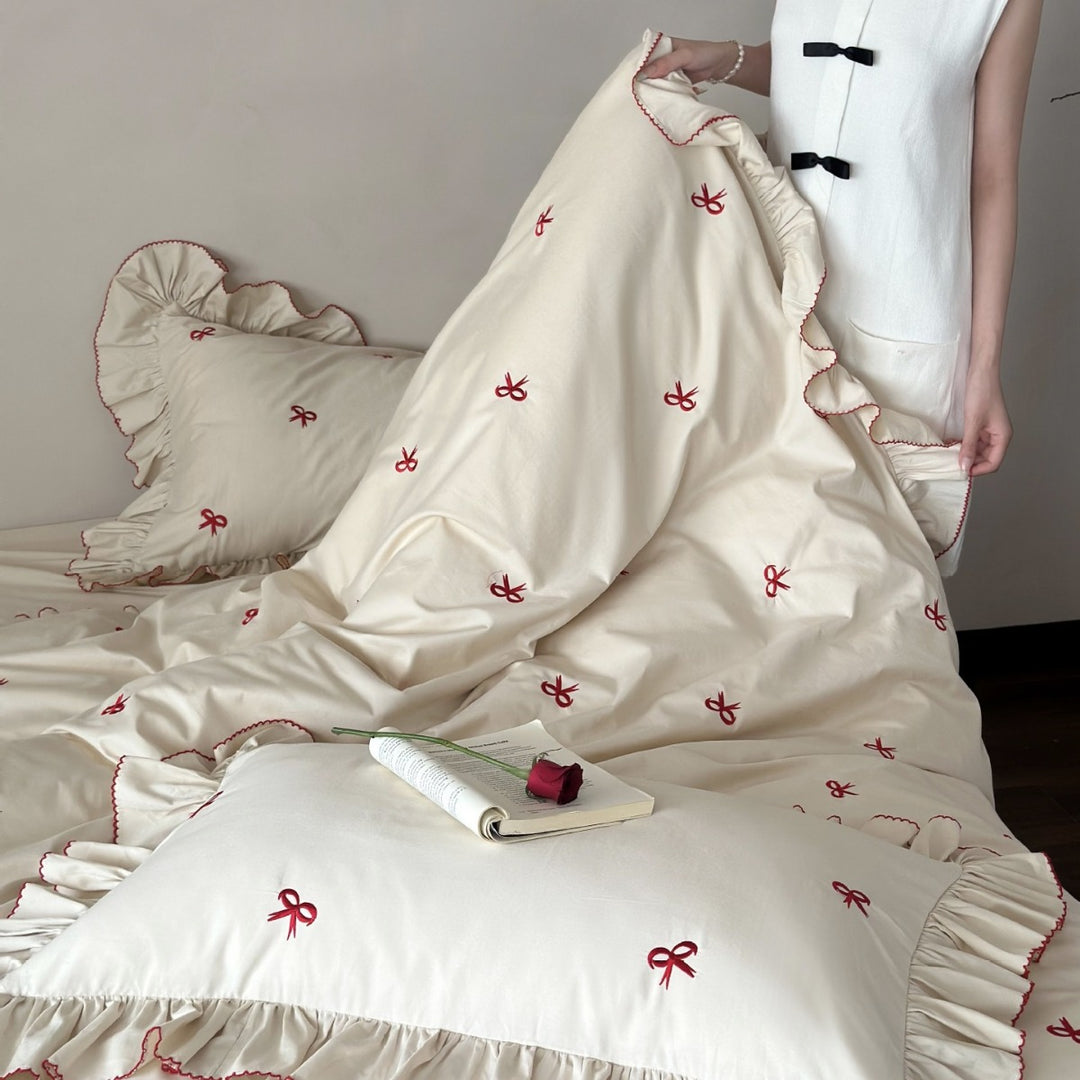 Ruffled bedding set with embroidered bows and frills