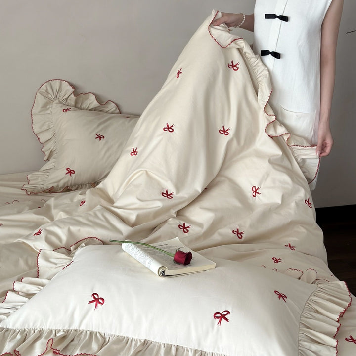 Ruffled bedding set with embroidered bows and frills