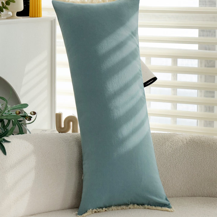 elongated decorative cushion with fringes and velvety surface