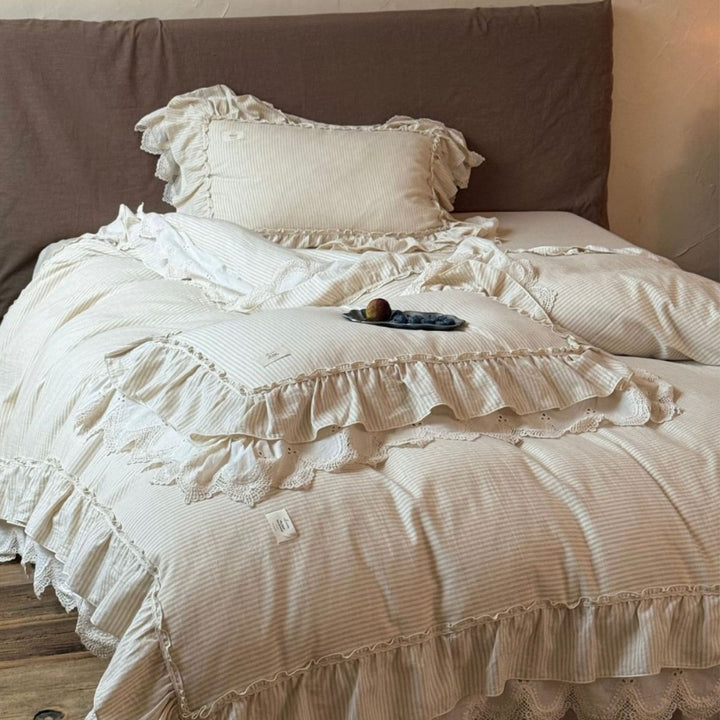 Country house style bed linen set with ruffles, lace border and quilted bedspread