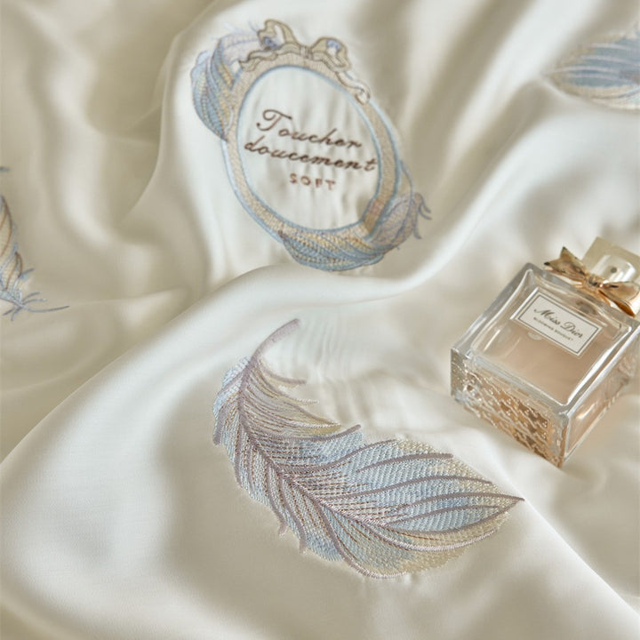 Reversible cotton satin bedding set with finely embroidered feather motifs and a silky-matte finish