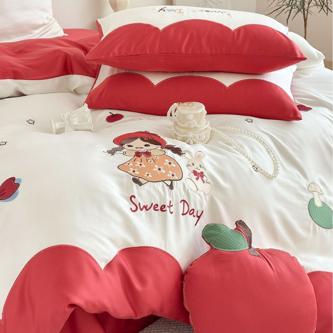 Bedding set with embroidered doll and apple motifs
