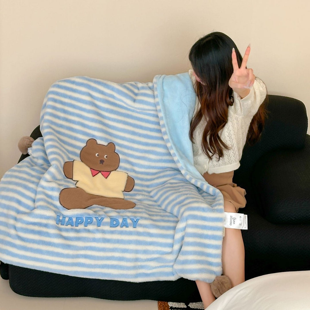 Plush cuddle blanket with striped texture, pom-pom corners & embroidered bear motif