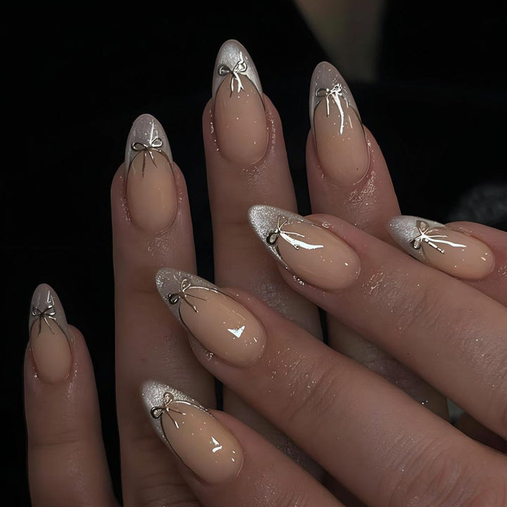 Nail art set with elegant black and white lace design and delicate bow embellishments Stornfield