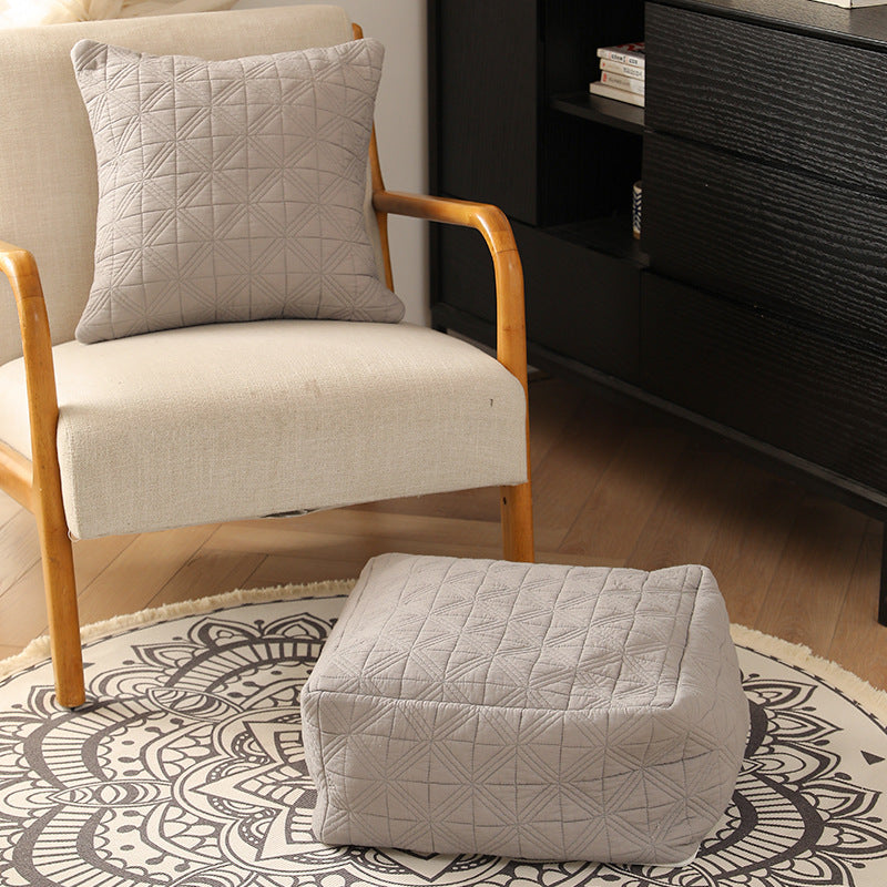 Padded footstool pouf with quilted cover fabric and shape-stable core