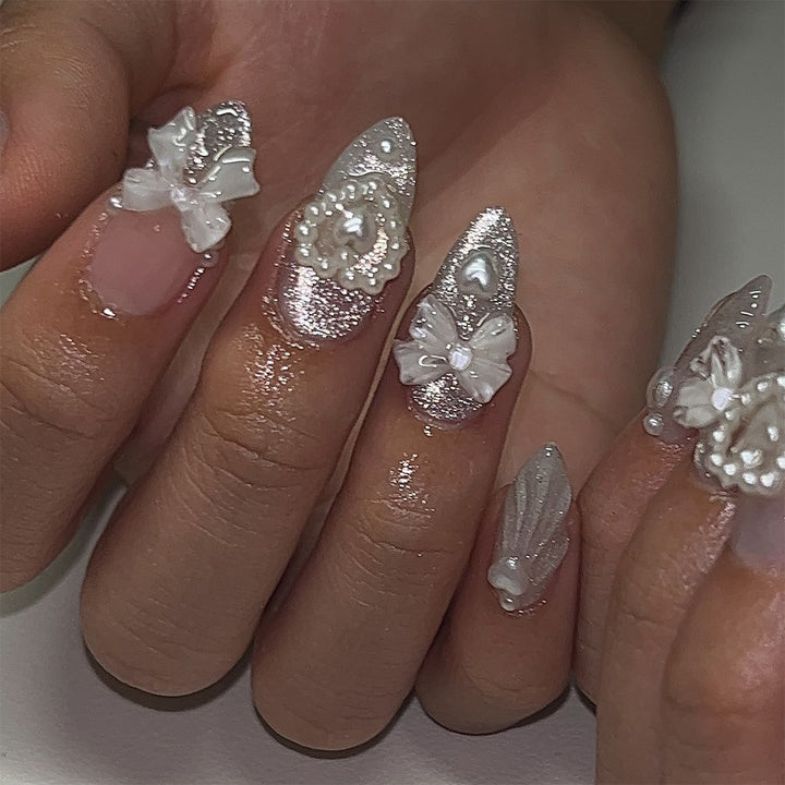 Artful nail decoration with pearl and bow accents Stornfield