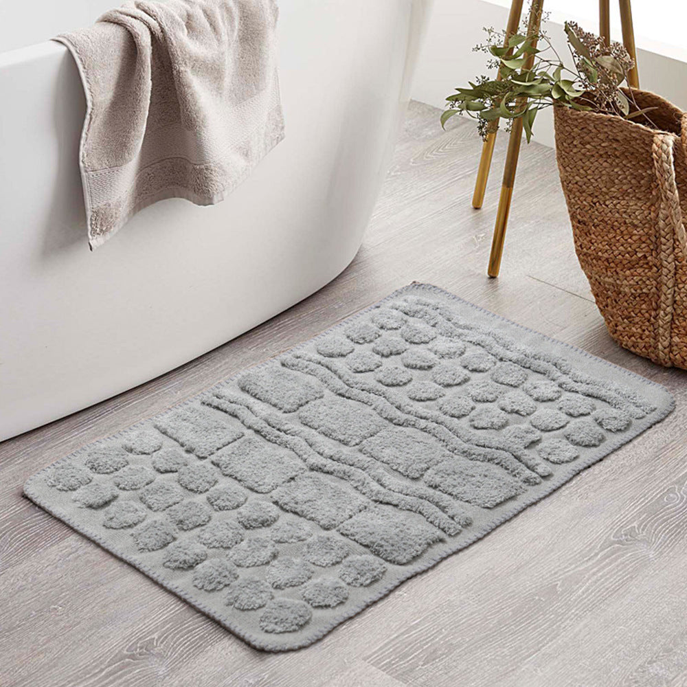 Rectangular cotton bath mat with abstract 3D tuft relief and non-slip back