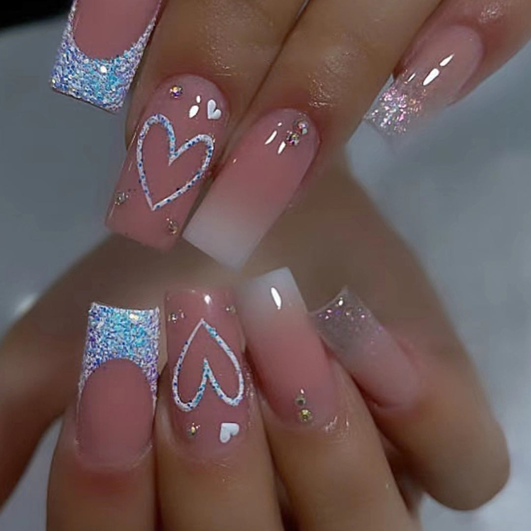 Artificial nails with sparkling heart designs and glitter details Stornfield