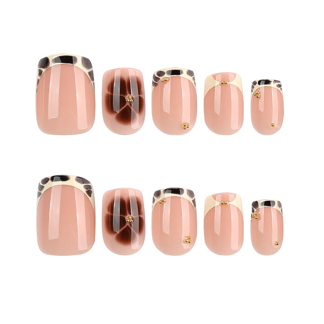 Artful nail extensions with an elegant giraffe pattern and golden accents Stornfield