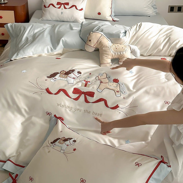 Children's bedding set made of cotton satin with embroidered rocking horse motif and contrasting hem