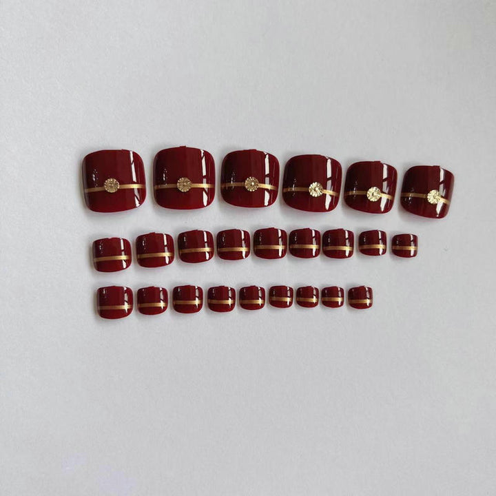 Artificial toenails with elegant gold embellishments Stornfield