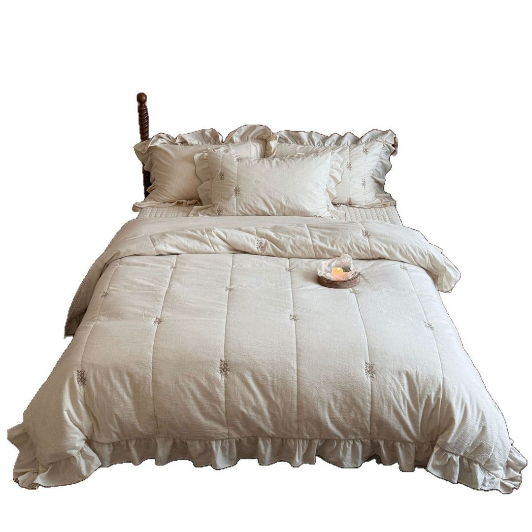 Bedding set in vintage look with ruffle, fine floral embroidery and quilted blanket