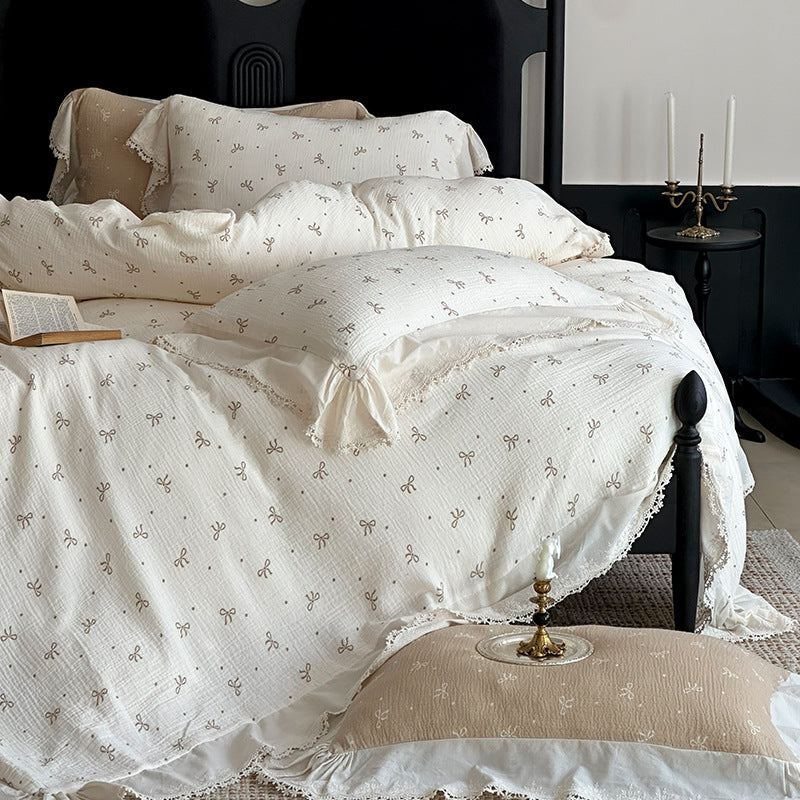 Cotton muslin bedding set with ruffles, lace trim, and delicate bow print