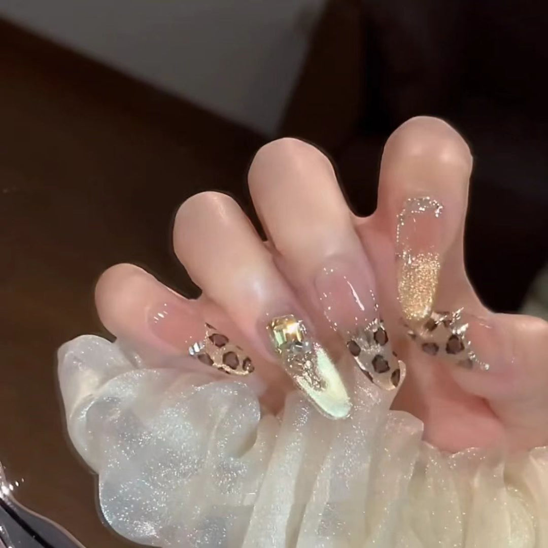 Glamorous artificial nails with elegant glitter accents and leopard details Stornfield