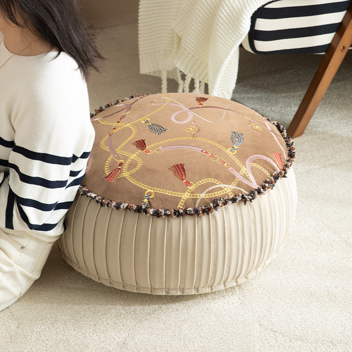 Beef seat pouf with embroidered top, pleated side panel and decorative fringe edge