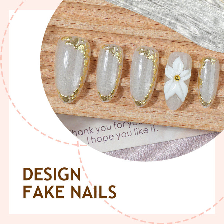 Acrylic nail set with elegant gold embellishments and floral accent Stornfield