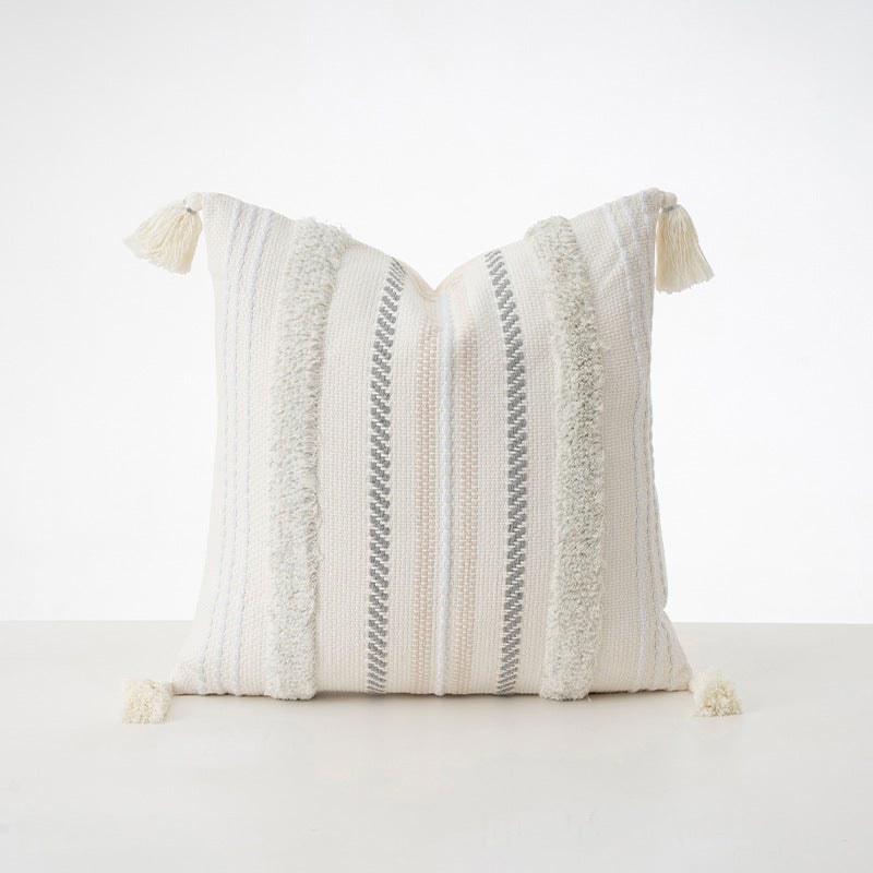 Square decorative cushion with boucle stripes, woven texture, and corner tassels