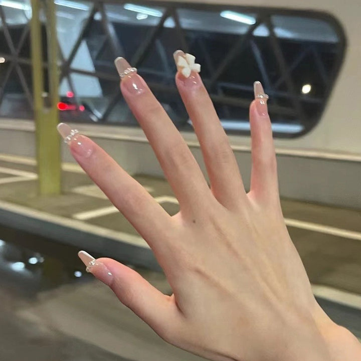Artificial nails with elegant bow accents and pearl decorations Stornfield