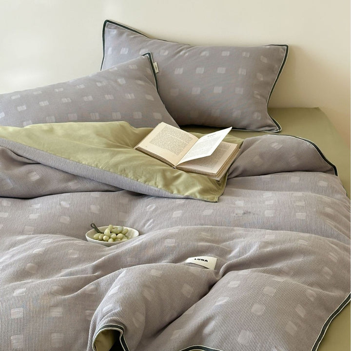 Reversible cotton bedding set with subtle square structure and contrast piping