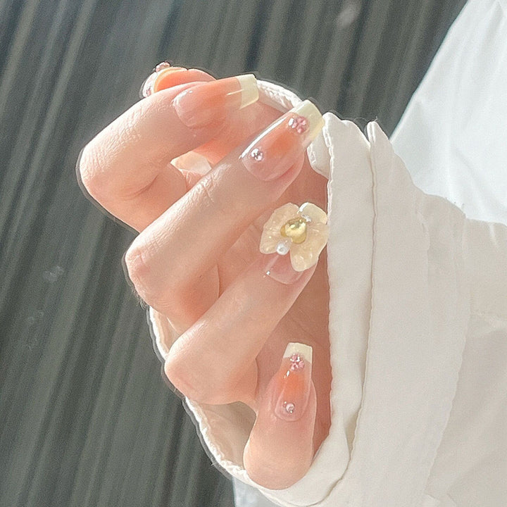Artificial nail set with elegant floral decorations and glitter accents Stornfield