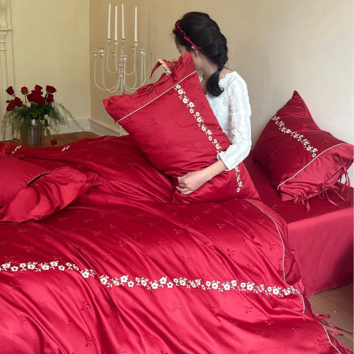 Bedding set made of cotton satin with floral border embroidery, decorative bows and pillow ensemble