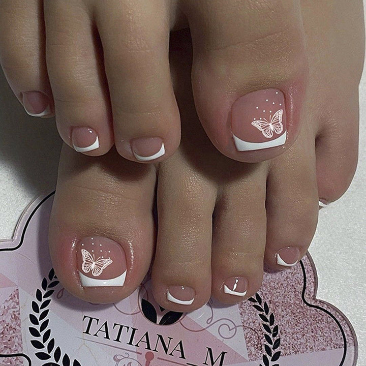 Artful toenail design with elegant butterfly motifs and French design Stornfield