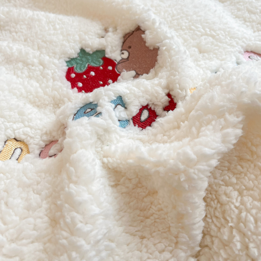 Plush quilt with teddy fleece, embroidered strawberry appliqués and reversible function