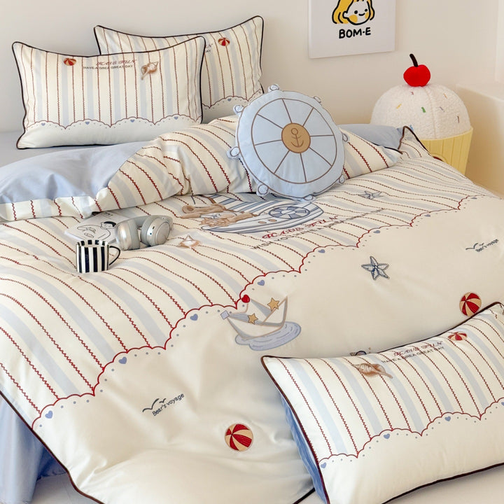 Children's bedding set with embroidered comic design and striped details