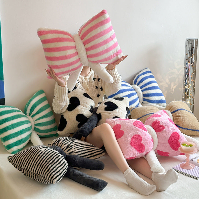 Cuddle cushion in bow shape made of plush with striped texture