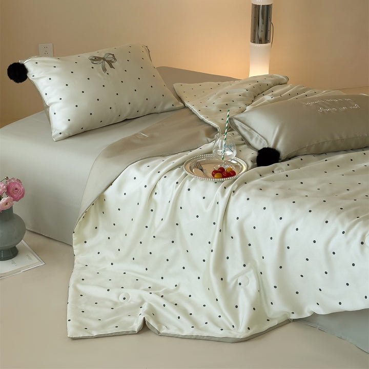 Luxurious satin bedding set with polka dot pattern and pom-pom tassels