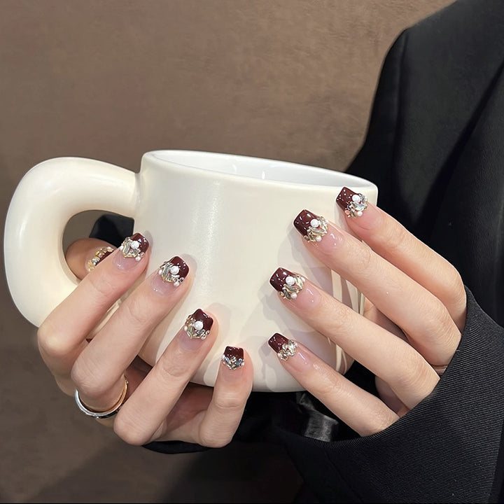 Glamorous artificial nails with decorative pearl and glitter embellishments Stornfield