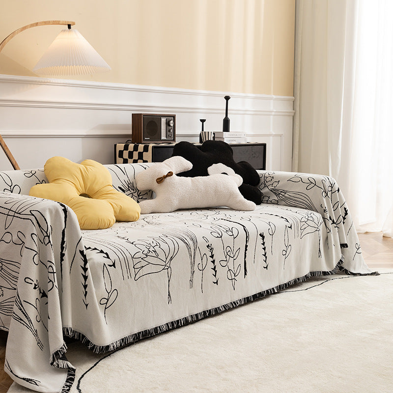 Light woven sofa cover with botanical line print and fringe hem