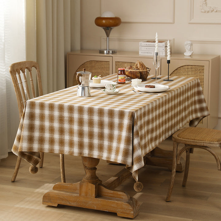 Rectangular checked tablecloth made of cotton blend with pom-pom corners