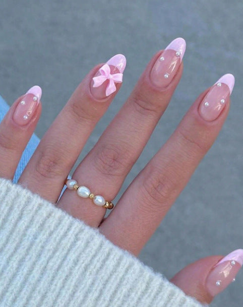Artificial nail set with shimmering 3D bows and elegant pearl accents Stornfield