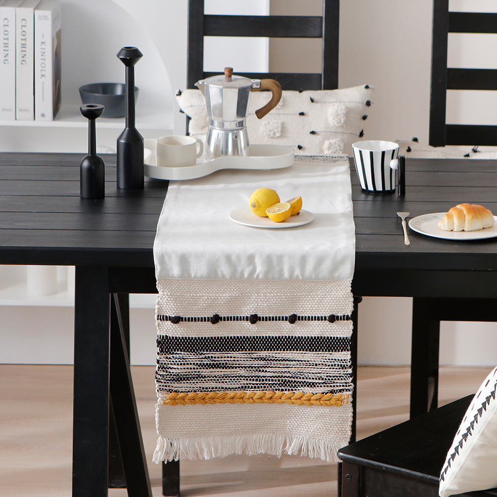 Woven decorative table runner with textured fringes and tactile weaving pattern
