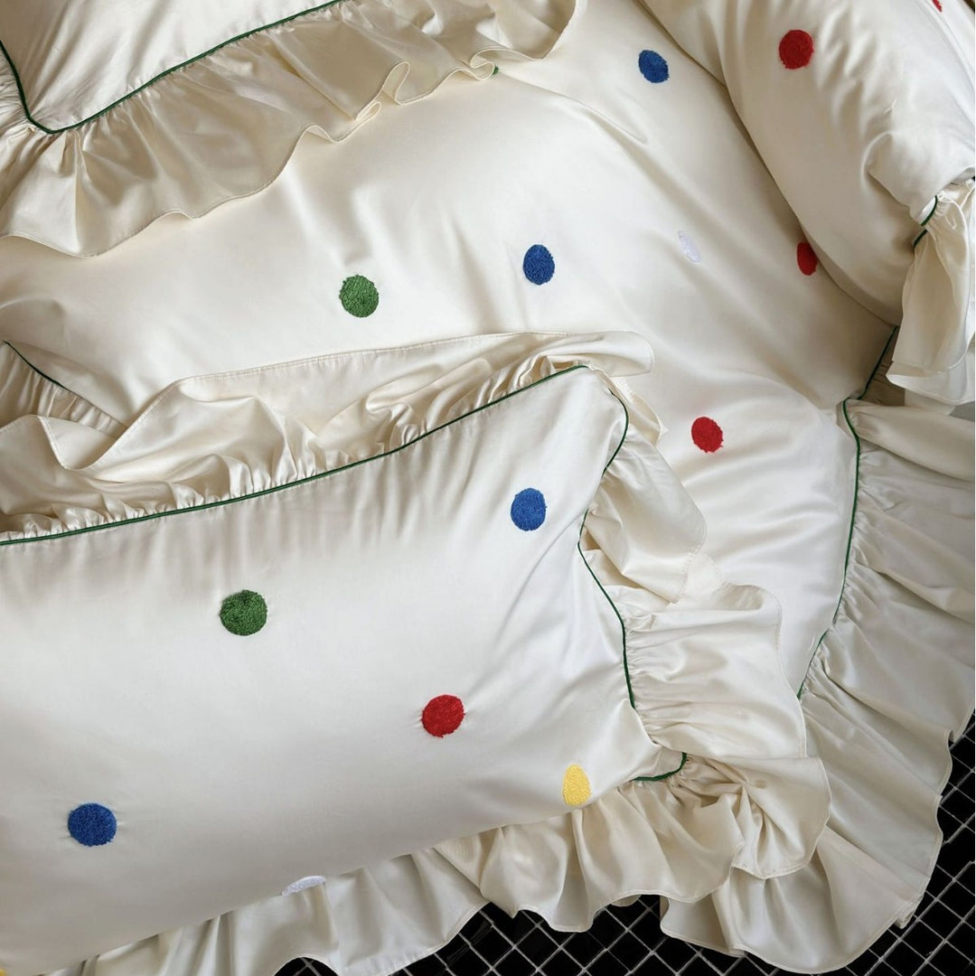 Playful bedding set with frill, colorful flock applications, and fine piping