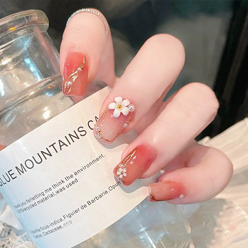 Acrylic nail set with elegant floral decorations and glamorous pearl accents Stornfield