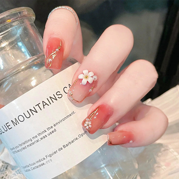 Acrylic nail set with elegant floral decorations and glamorous pearl accents Stornfield