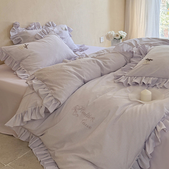 Ruffled bed linen set with fine striped texture and decorative frill