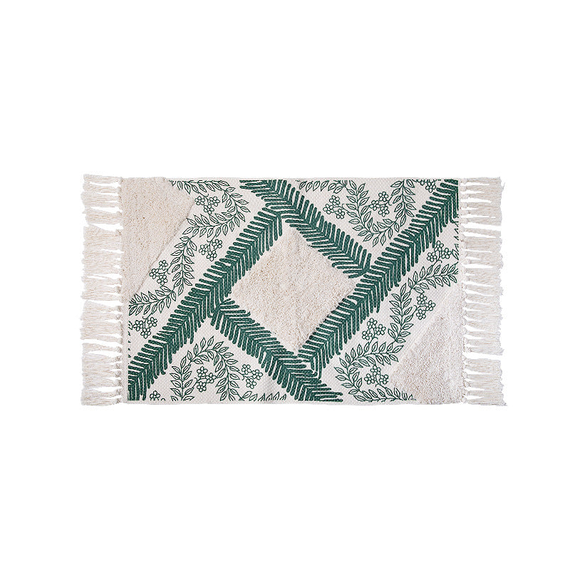 Hand-tufted cotton bath mat with botanical pattern and decorative fringes