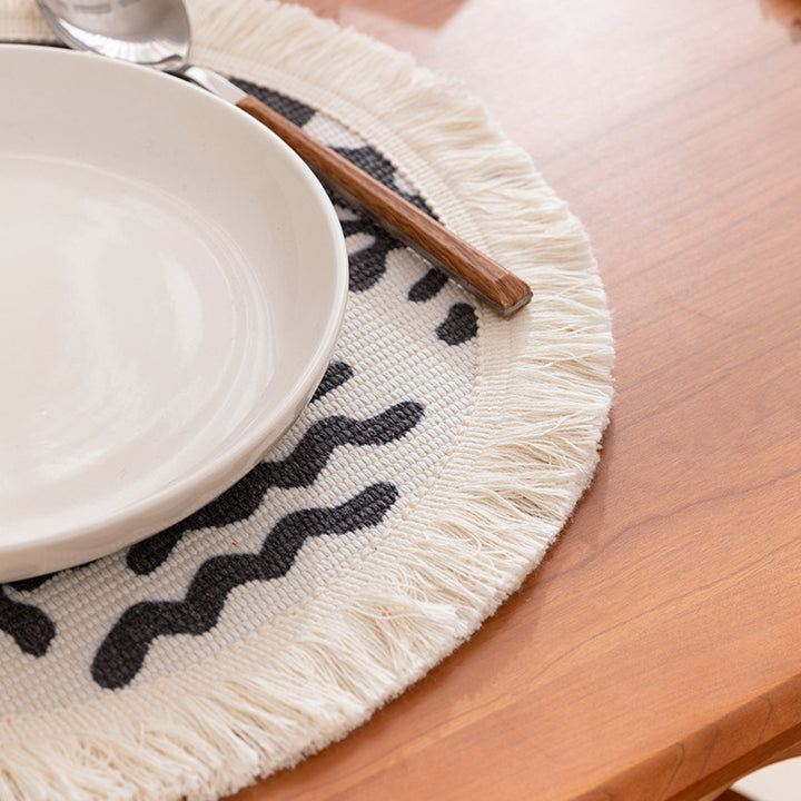 Round woven placemat with fringes and abstract figure motif Stornfield