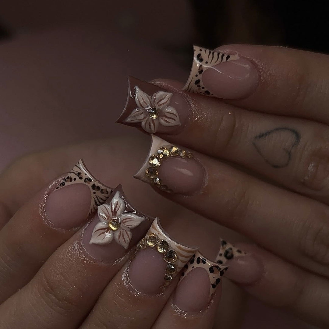 Artificial nail set with floral embellishments and elegant glitter details Stornfield