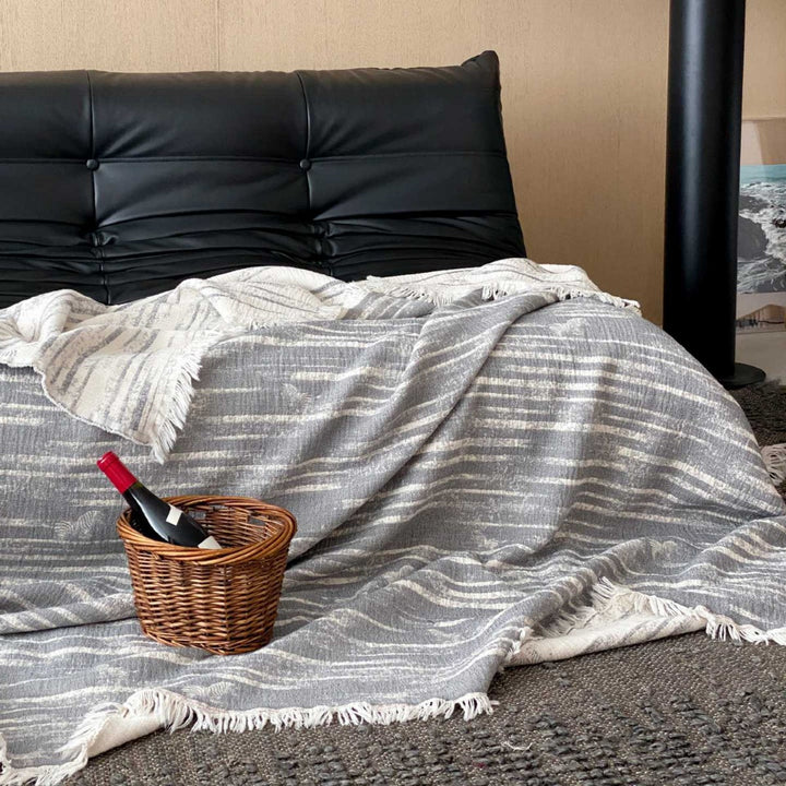 Cozy living blanket made of cotton blend fabric with fringes and striped texture