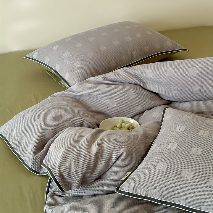 Reversible cotton bedding set with subtle square structure and contrast piping