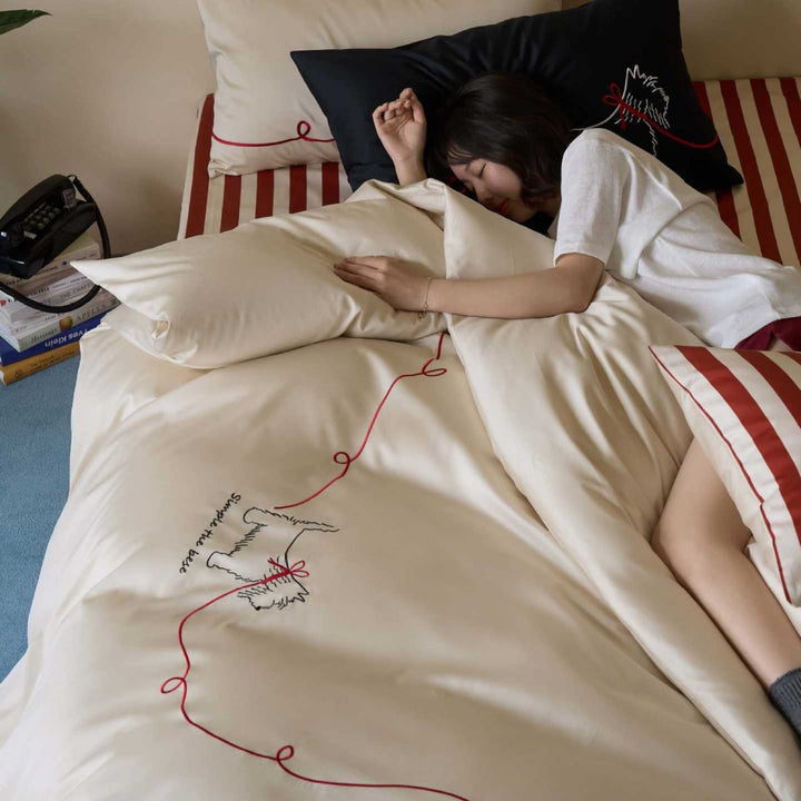 Cotton satin bedding with embroidered dog motif and red cord
